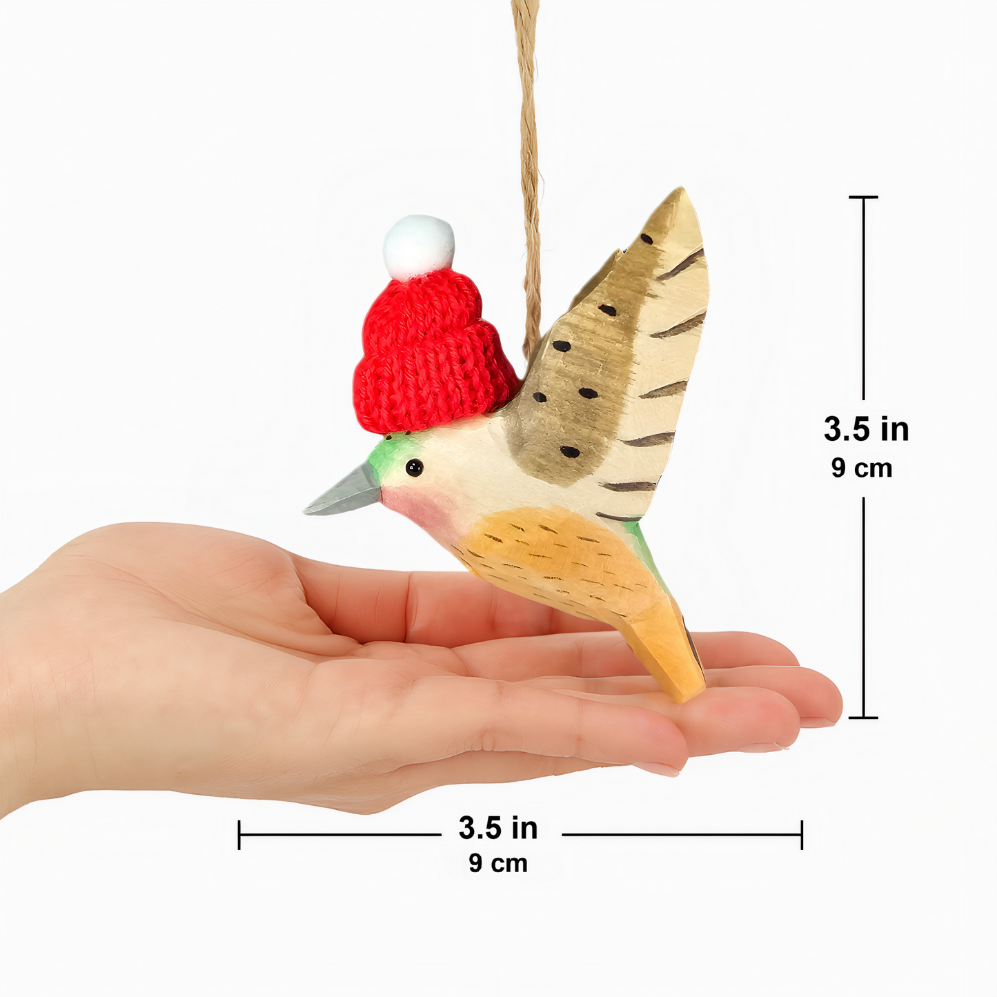 Decorative bird ornament with a red hat held in a hand, with measurements indicated.